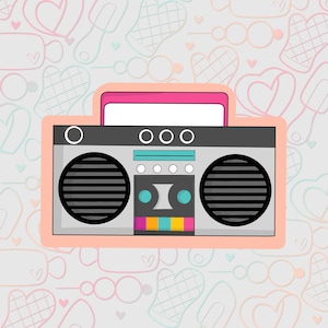 Puede incluir: Un boombox de estilo retro con un esquema de color rosa y gris. El boombox tiene un reproductor de casetes, un sintonizador de radio y dos altavoces. El boombox está situado sobre un fondo de corazones blancos y rosas.
