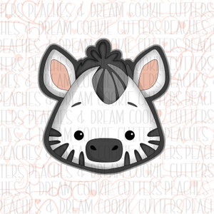 May include: A black and white zebra face cookie cutter. The cookie cutter is made of metal and has a detailed design.