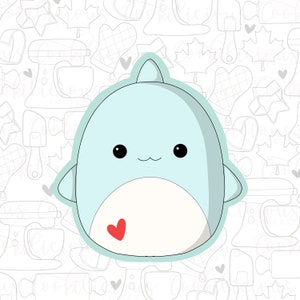 May include: A light blue cartoon whale with a small red heart on its belly. The whale has a cute, smiling face with big black eyes.