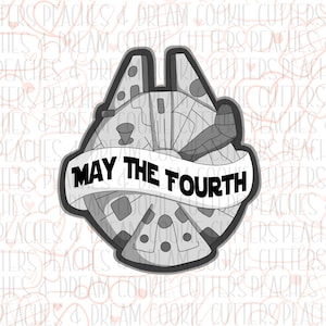 May include: A black and white cookie cutter shaped like the Millennium Falcon from Star Wars with the text "May the Fourth" on a banner.