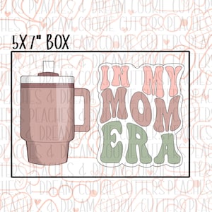 May include: A 5x7 inch box cookie cutter set featuring a pink and brown mug and a green, pink, and brown "In My Mom Era" text design.