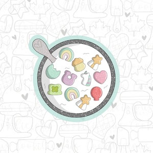 May include: A white ceramic bowl filled with colorful marshmallow cereal. The bowl is on a white background with a pattern of kitchen tools and shapes.