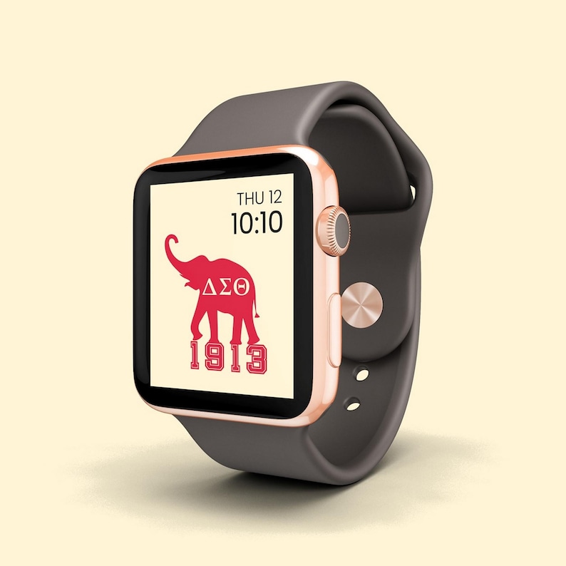 May include: A rose gold Apple Watch with a dark gray band. The watch face displays the date, time, and a red elephant with the letters "&Delta;&Sigma;&Theta;" and the number "1913".