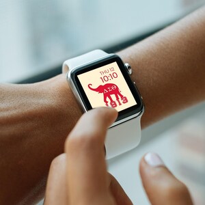 May include: A white smartwatch with a red elephant and Greek letters on the screen. The screen also displays the date and time, "THU 12 10:10" and "1913".