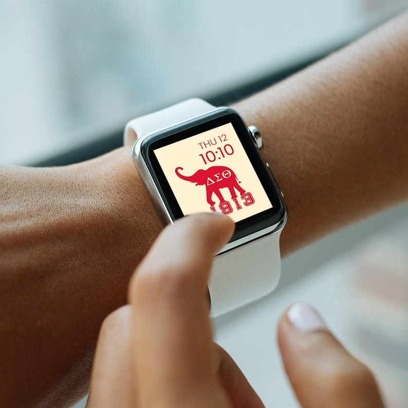 May include: A white smartwatch with a red elephant and Greek letters on the screen. The screen also displays the date and time, "THU 12 10:10" and "1913".