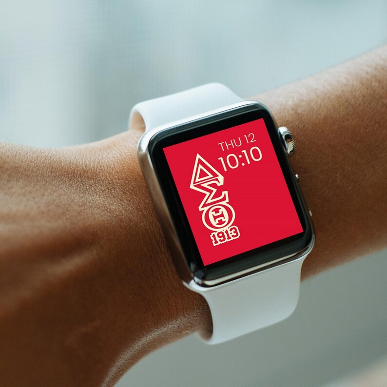 May include: A white smartwatch with a red face displaying the time 10:10 and the text "THU 12". The face also features a white Greek letter design with the text "1913".