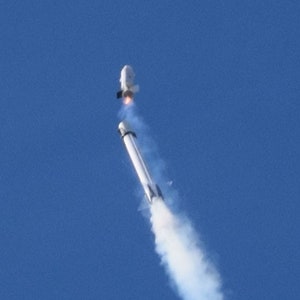 May include: A white rocket with a plume of smoke trailing behind it as it ascends into a clear blue sky.