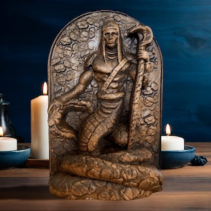 May include: A wooden sculpture of a snake-like creature with a human head and torso. The sculpture is carved in a detailed style and has a dark brown finish. The sculpture is set against a blue background and is surrounded by candles.