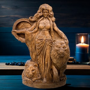 May include: Wooden sculpture of a woman with long flowing hair, holding a round object and standing with two lions. The sculpture is painted in shades of brown and has a rustic look.