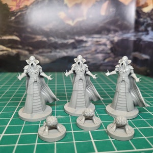 May include: Three grey painted miniature figures of humanoid figures with tentacles for heads, wearing robes and standing on circular bases.  There are three additional grey painted miniature figures of tentacled creatures on circular bases.