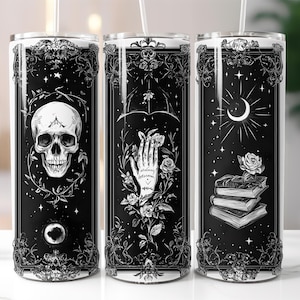Puede incluir: Tres vasos de acero inoxidable en blanco y negro con diferentes diseños. El primer vaso presenta una calavera con una luna creciente y estrellas. El segundo vaso presenta una mano con una rosa y las palabras "Siempre cree". El tercer vaso presenta una pila de libros con una rosa y una luna creciente.