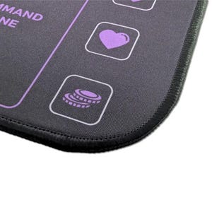 Close-up of the stitched edge and purple icons on the Commander Mini Dashboard playmat