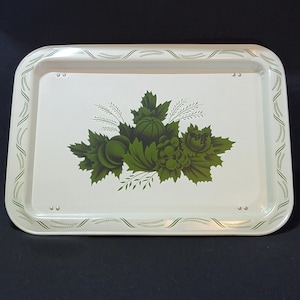 May include: A white metal serving tray with a green border and a green floral design featuring grapes and leaves.