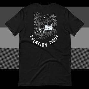 May include: A black short-sleeved t-shirt featuring a white line-art graphic on the back. The design depicts two figures wearing hats, sunglasses, and floral shirts while typing on keyboards under palm trees, with the text VACATION MODE below.