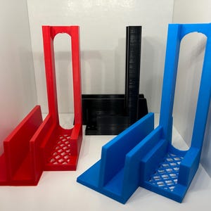 May include: Three 3D printed stands in red, blue, and black. Each stand has a vertical slot and a horizontal slot for holding items.