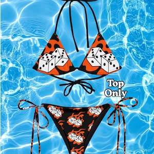 May include: A two-piece bikini set featuring a black and orange flame pattern with white dice graphics. The top is a triangle style with black halter ties, and the bottom has side ties. The text Top Only is printed on the right side.