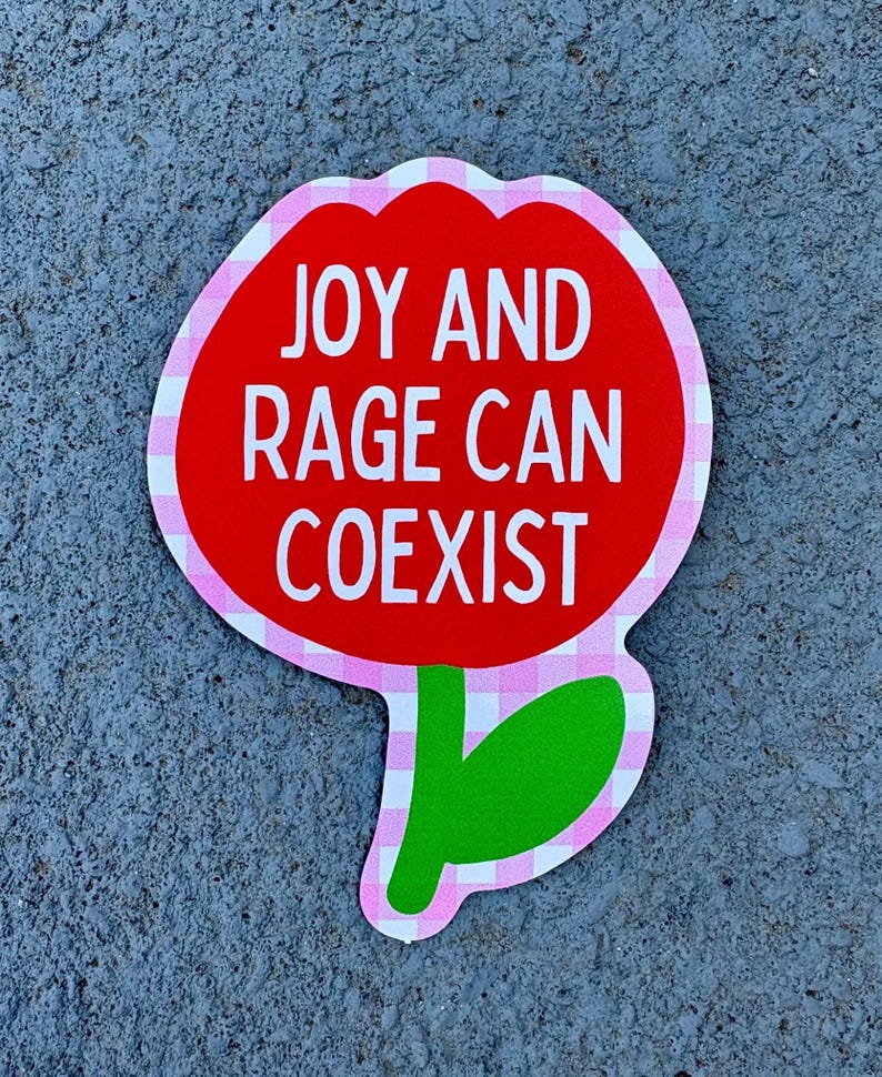 Peut inclure: Un autocollant rouge en forme de fleur avec le texte "JOY AND RAGE CAN COEXIST" en blanc. La fleur a une bordure rose et blanche &agrave; carreaux et une tige et une feuille vertes.