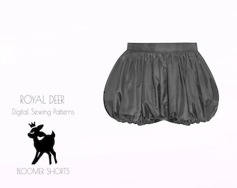 May include: A pair of gray bloomers with a gathered waist and hem. The image includes the text "ROYAL DEER Digital Sewing Patterns" and a silhouette of a deer wearing a crown. The text "BLOOMER SHORTS" is also present.