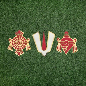 May include: Three decorative religious symbols in red and gold, set against a green background. The central symbol is a white and red V-shape with gold trim. Flanking it are two ornate, symmetrical designs.