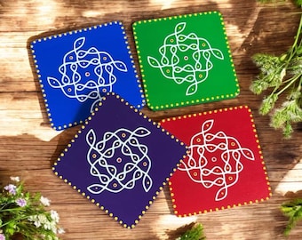 May include: Four square coasters in blue, green, purple, and red. Each coaster features a white, intricate design and a dotted border. The coasters are arranged on a wooden surface, showcasing a vibrant and colorful aesthetic.