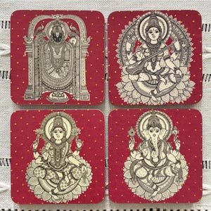 Pode incluir: Conjunto de quatro bases quadradas com figuras religiosas. Cada base apresenta uma divindade diferente em uma ilustra&ccedil;&atilde;o detalhada em preto e branco sobre um fundo vermelho com pequenos pontos dourados. As bases s&atilde;o provavelmente feitas de material absorvente.