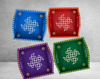 May include: Four square serving trays in blue, red, purple, and green. Each tray features a white hand-painted geometric kolam pattern in the center, small yellow floral accents in the corners, and a yellow dotted border along the edges.