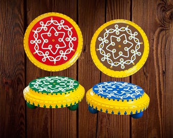 May include: Four round wooden stands with yellow edges and colorful tops featuring white hand-painted floral patterns. Two stands are flat discs, while two are raised on small feet. The tops are red, brown, green, and blue with white details.
