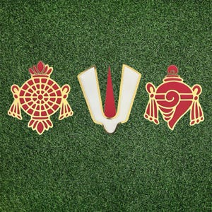 May include: Three decorative religious symbols in red, gold, and white, set against a green background. The central symbol is a white 'V' shape with a red center. The other two are ornate, symmetrical designs in red and gold.