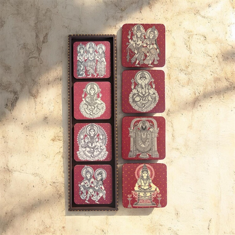 Pode incluir: Um conjunto de oito bases quadradas com figuras religiosas brancas sobre um fundo vermelho. As bases s&atilde;o apresentadas num suporte de madeira castanha. Cada base apresenta uma divindade ou cena diferente, com desenhos detalhados a tra&ccedil;o.