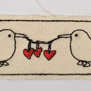 Broderad stryklapp på duk - kiwi och en girlang av hjärtan