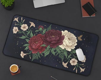 May include: A rectangular desk mat with a floral design. It features burgundy, red, and cream peonies, green leaves, and a moth against a dark blue background. The mat has a black border and is surrounded by office supplies.