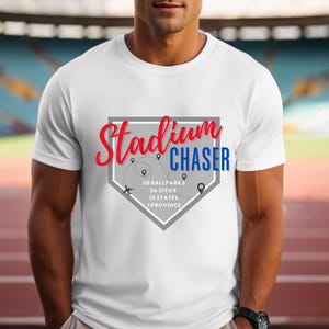 Puede incluir: Camiseta blanca con un gráfico de diamante de béisbol gris. El gráfico dice "Stadium Chaser" en texto rojo y azul. El gráfico también incluye el texto "30 Ballparks, 26 Cities, 15 States, 1 Province".