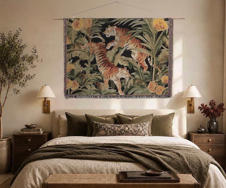 Puede incluir: Un tapiz de pared tejido rectangular que muestra dos tigres merodeando a trav&eacute;s de una densa selva de hojas de palma verdes y grandes flores amarillas. La pieza textil tiene un fondo oscuro y bordes con flecos en los cuatro lados.