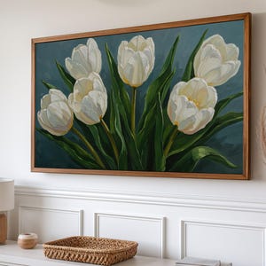 以下が含まれることがあります： 濃い青色の背景に、白いチューリップと緑の葉が描かれた額装された絵画です。