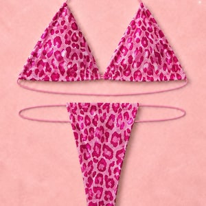 May include: A two-piece bikini set featuring a vibrant pink and magenta leopard print pattern. The top consists of two triangular cups with thin pink string ties, while the bottom is a high-cut thong style with matching thin side ties.