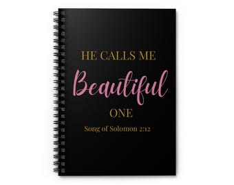 May include: Black spiral-bound notebook with the text "HE CALLS ME Beautiful ONE" in gold and pink lettering. The bottom of the notebook has the text "Song of Solomon 2:12".