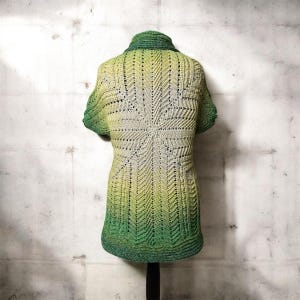 May include: A green and yellow crocheted top with a collar and short sleeves. The openwork design features a starburst pattern on the back and a gradient effect, transitioning from green to yellow.