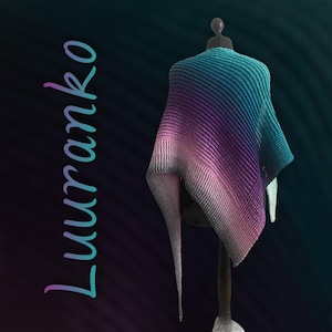 May include: A teal, purple, and white gradient knitted shawl displayed on a mannequin. The shawl is made of a soft, textured yarn and has a triangular shape.