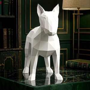 May include: A white, geometric, low-poly sculpture of a Bull Terrier dog. The figure is constructed from flat, angular planes that form the shape of the animal, featuring pointed ears, a distinct snout, and a standing posture on four legs.