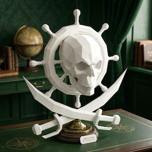Puede incluir: Una escultura de papel blanco de estilo low-poly que presenta un cráneo humano centrado en un timón de barco, colocado sobre dos espadas cruzadas. El conjunto está montado sobre una base de madera con una etiqueta Artisan Papercraft.