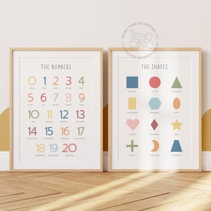 May include: Two framed educational prints. One displays numbers 0-20 in various colors, the other shows shapes like squares, circles, and triangles. Both prints have a light wood frame and are designed for children's learning.