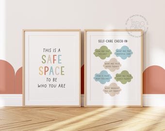 May include: Two framed prints with inspirational text. One reads "This is a safe space to be who you are" in colorful letters. The other is a self-care check-in with prompts like "How are you feeling?" and "What are you grateful for?"