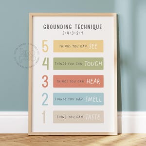 Könnte beinhalten: Ein druckbarer Poster mit einer Erdungstechnik zur Bewältigung von Angstzuständen. Das Poster hat einen hellblauen Hintergrund mit einem Holzrahmen und einem weißen Hintergrund. Das Poster enthält eine Liste von fünf Dingen, auf die man sich konzentrieren kann: sehen, fühlen, hören, riechen und schmecken. Das Poster trägt den Titel "Erdungstechnik 5-4-3-2-1".