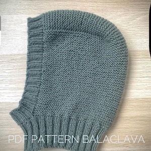 May include: A green knitted balaclava with a fold-over brim. The image includes the text "PDF PATTERN BALACLAVA".