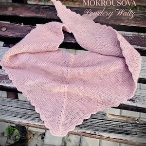 May include: A dusty pink triangular knitted shawl featuring a garter stitch texture and a delicate scalloped edge. The text OLGA MOKROUSOVA Powdery Waltz is printed in the upper right corner of the image above the fabric.