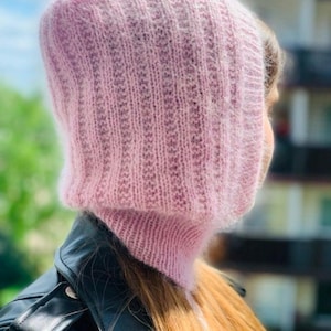 May include: A pink knitted hooded scarf with a fuzzy texture.