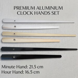 May include: A set of premium aluminum clock hands in silver, light gold, and black. The minute hand is 8.5 inches long, and the hour hand is 6.5 inches long. The text "PREMIUM ALUMINIUM CLOCK HANDS SET" is at the top.
