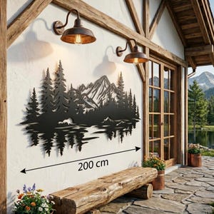 May include: Black metal wall art depicting a mountain and forest scene, approximately 78 inches wide, mounted on a white wall. Two bronze-colored outdoor lights are above the art. A wooden bench sits below the art.