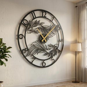 May include: A large, round, black metal wall clock featuring a koi fish design. The clock has gold-colored hands and a black face. The numbers are cut out of the metal, and the clock is mounted on a white wall.