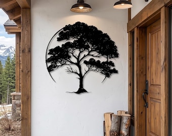 Könnte beinhalten: Ein Wandkunstobjekt aus schwarzem Metall, das die detaillierte Silhouette eines Baumes innerhalb eines kreisförmigen Rahmens zeigt. Das Design weist filigrane Äste und dichtes Blattwerk auf und ist an einer weißen Wand zwischen zwei dunklen Außenleuchten montiert.